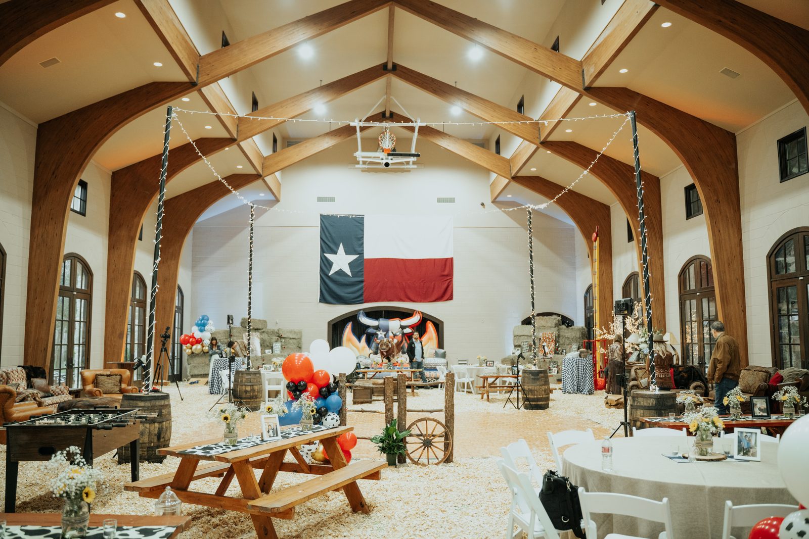 Outdoor engagement party with string lights, picnic tables and lounge seating