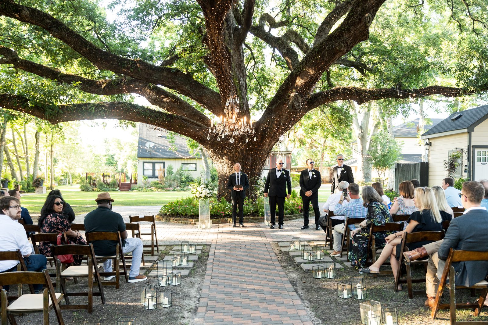 Wide ceremony aisle beneath the oak tree at Oak Tree Manor