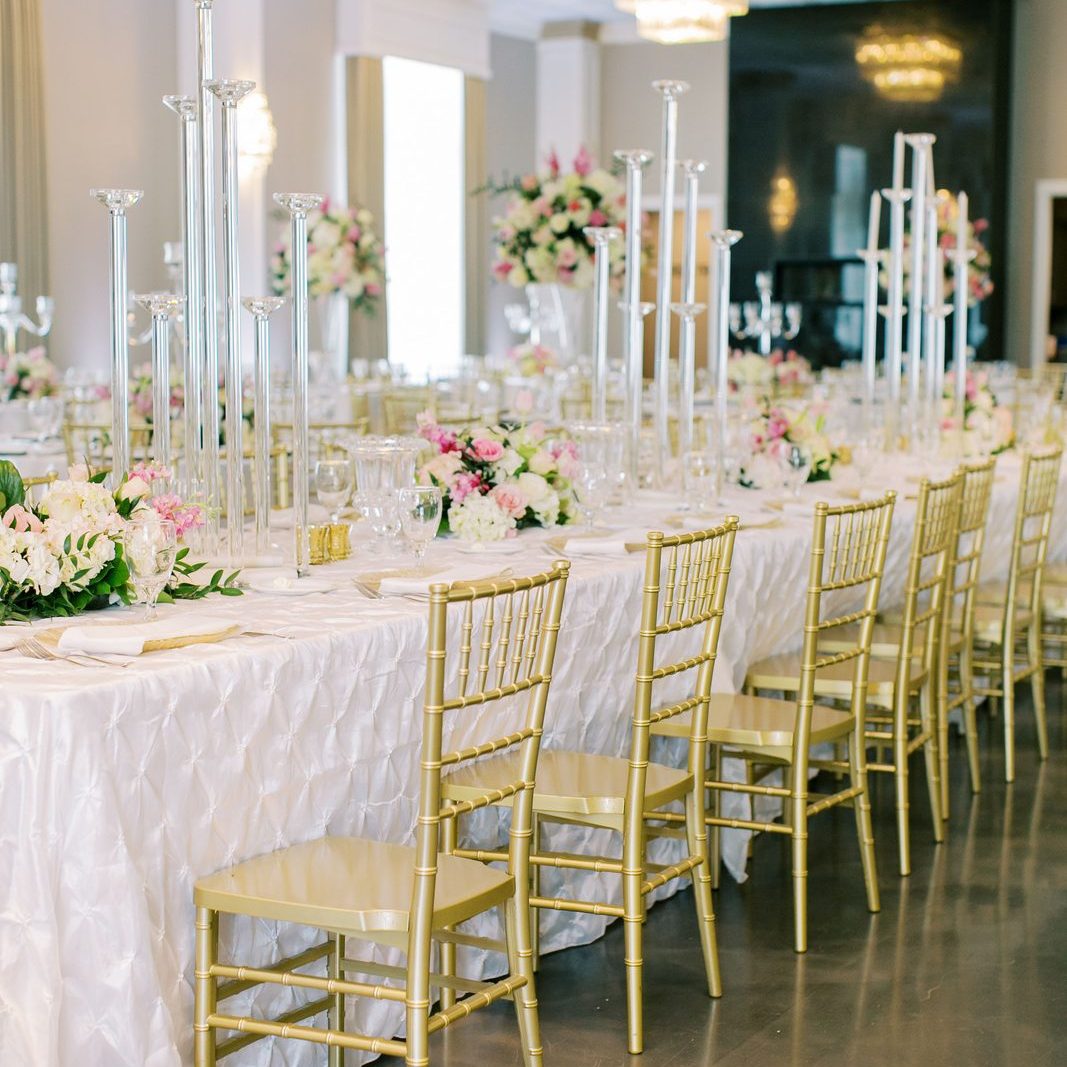 Wedding reception tablescape with gold chiavari chairs and tall crystal candlesticks