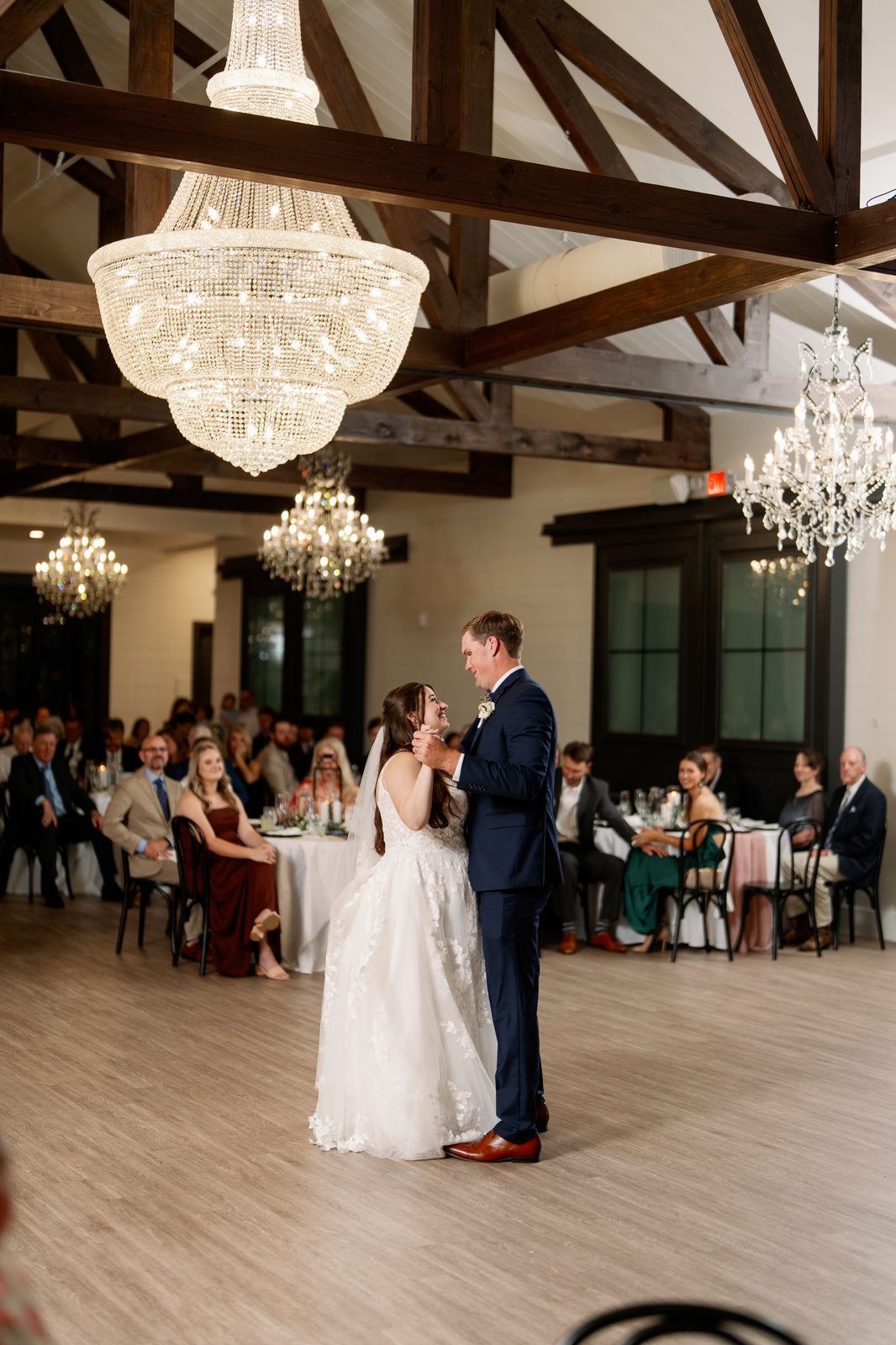 The Stables on the Brazos reception hall with chandeliers and wood beams