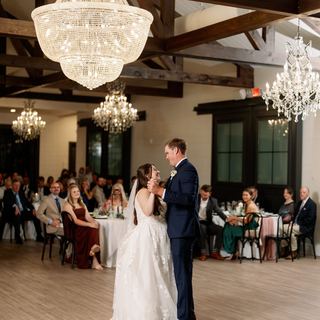 The Stables on the Brazos reception hall with chandeliers and wood beams